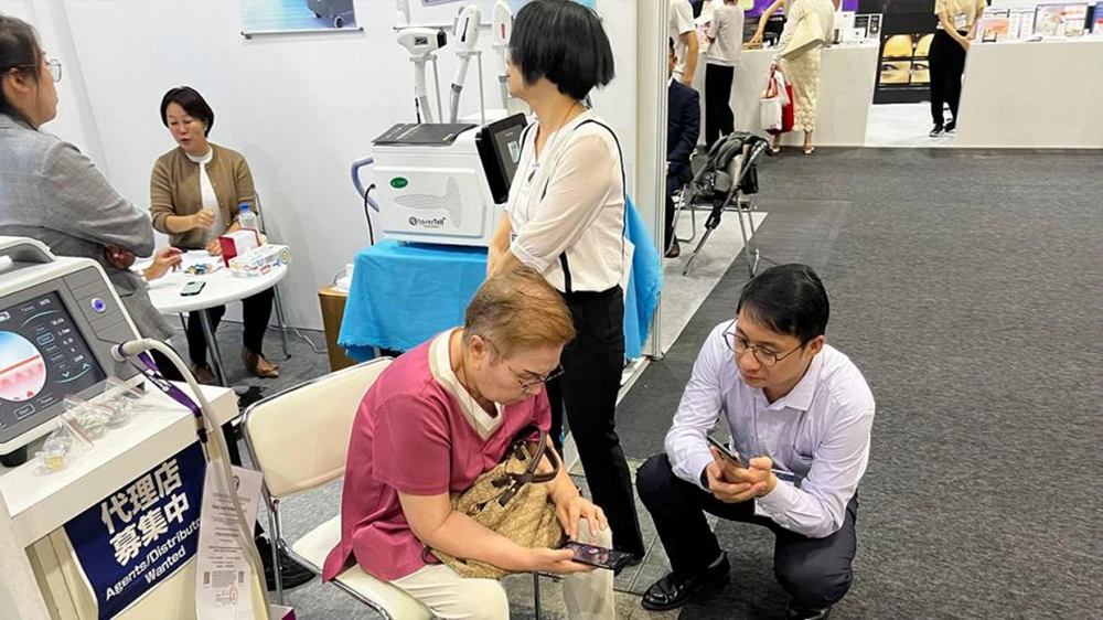 LaserTell sales representative consulting with a B2B client about aesthetic device distribution at COSME OSAKA