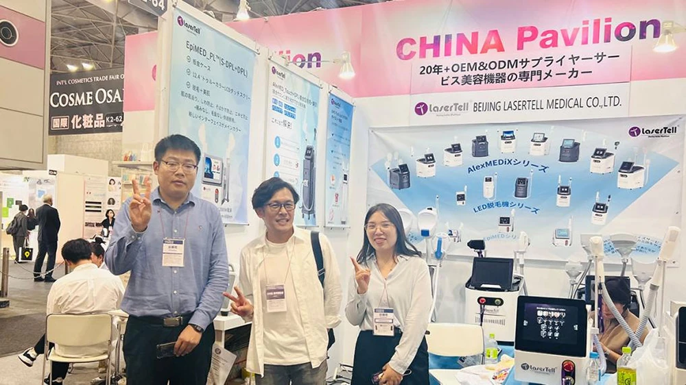 LaserTell representatives and visitor inside booth K2-64 exhibiting beauty laser devices at COSME OSAKA