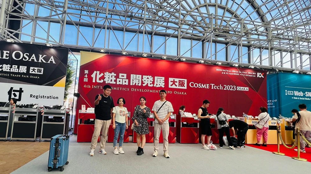 LaserTell team members posing at the entrance of COSME OSAKA 2023 trade show in INTEX Osaka Japan